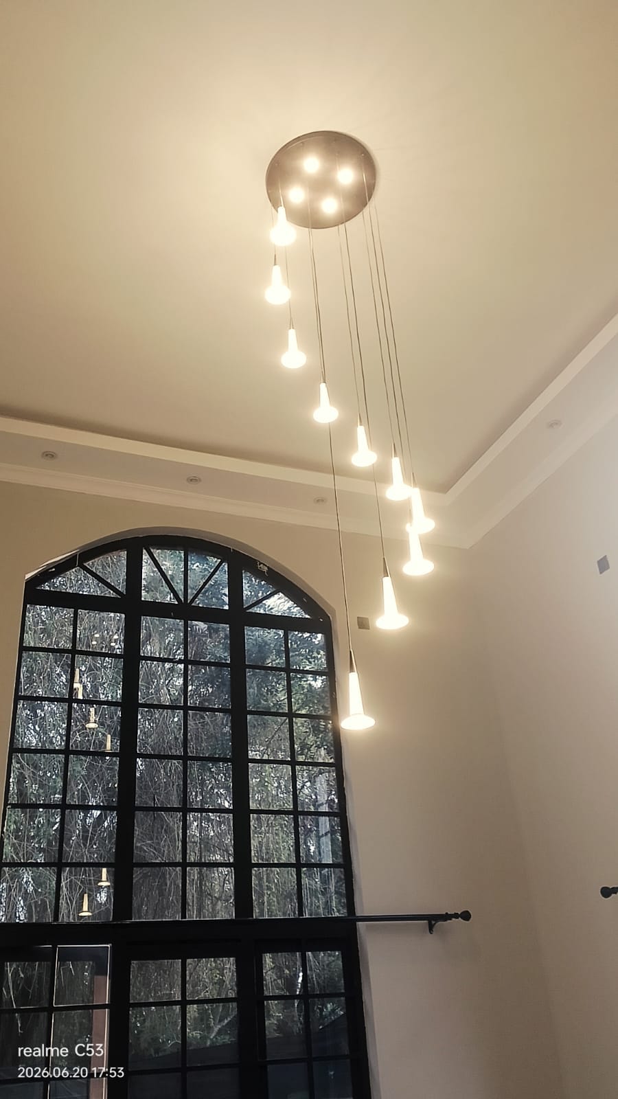 Double-height entrance with designer chandelier and arched window